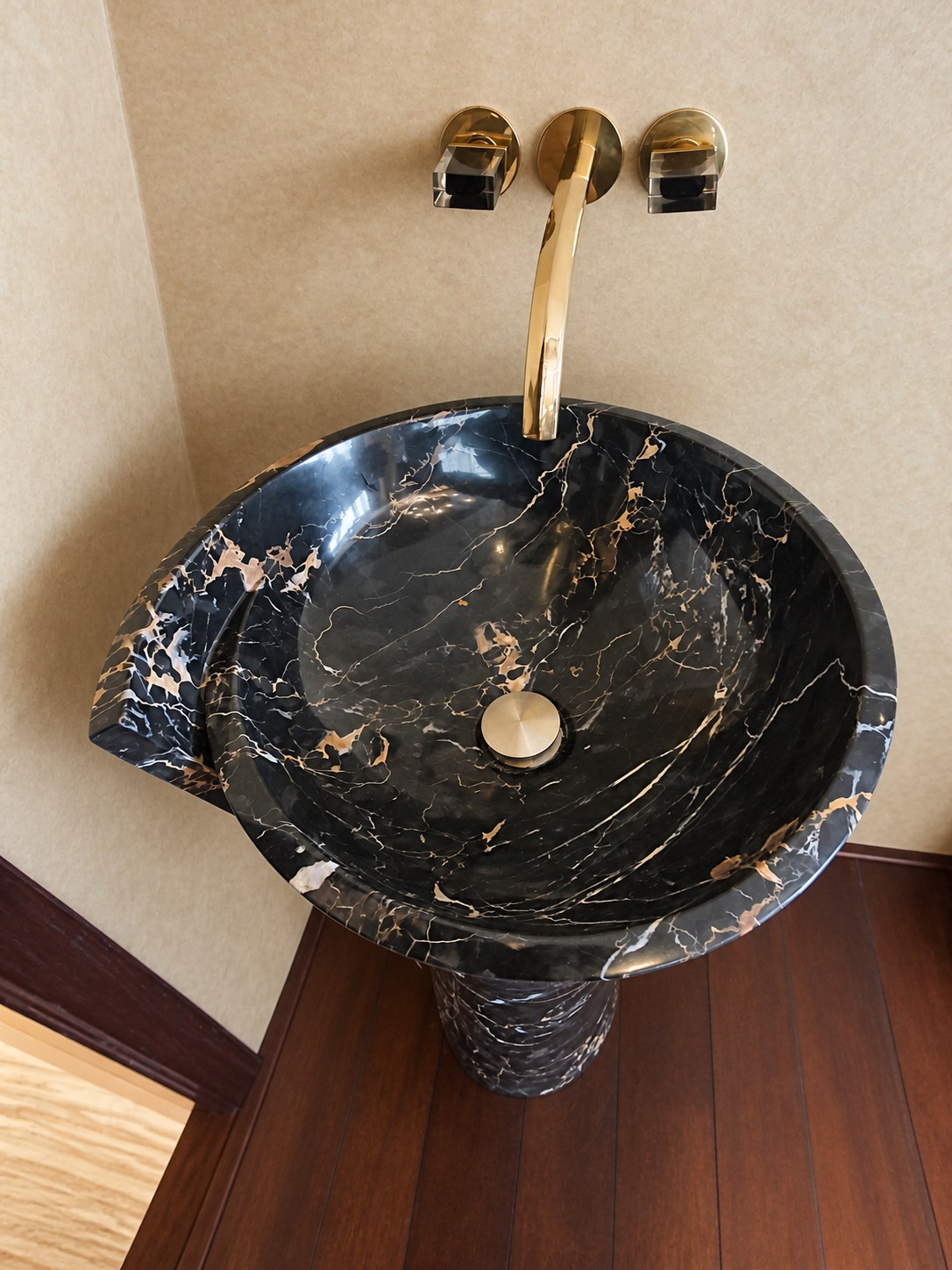 Solid Portoro basin with gold Fantini wall-mounted fittings.