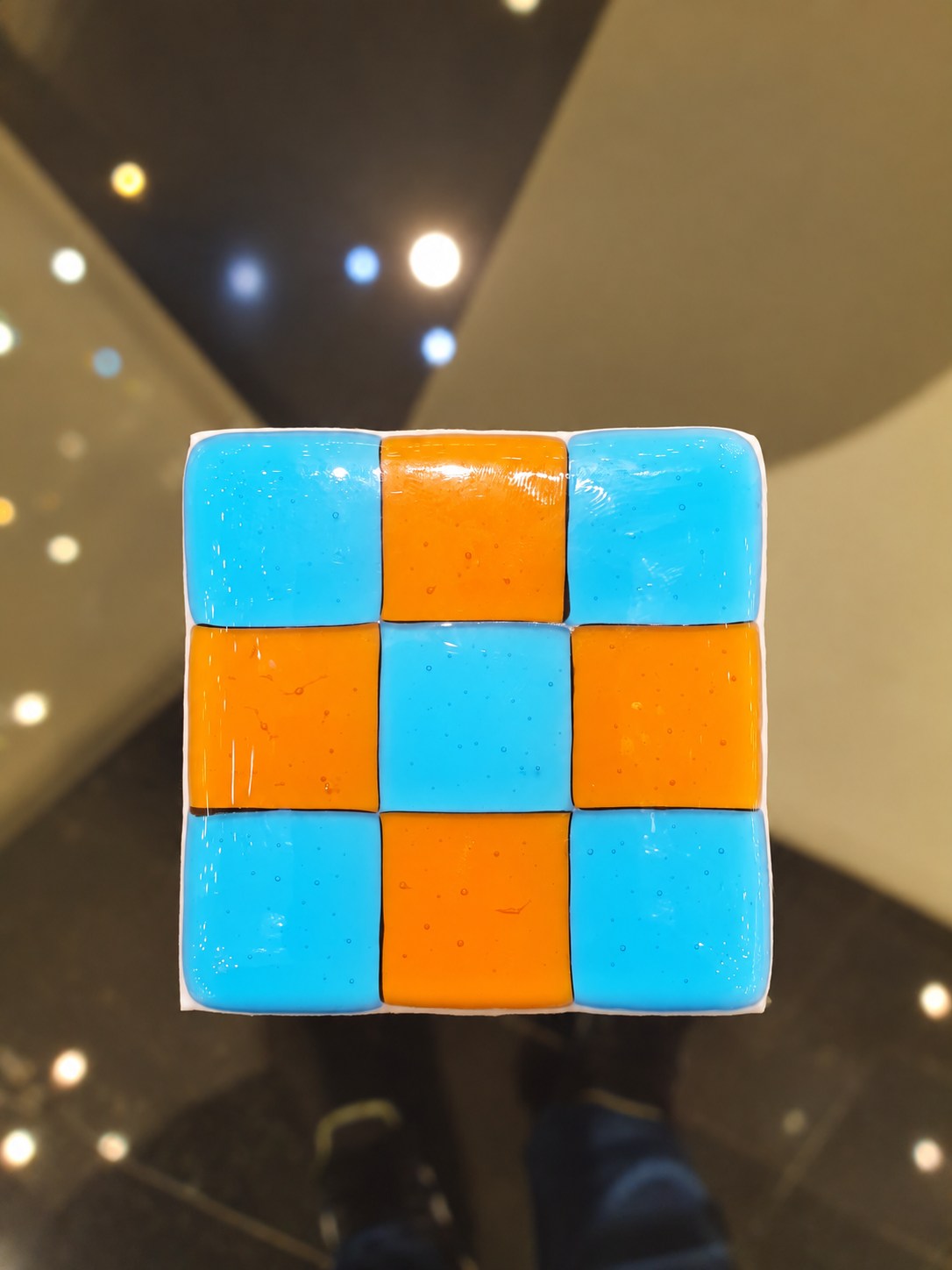 Orange and turquoise glass sample with a nine-square pattern.